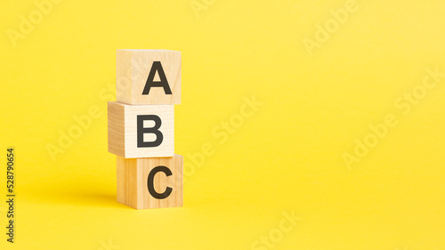 ABC - text on wooden cubes, on yellow background