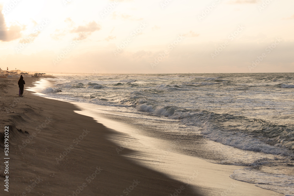 Waves hitting the beach at sunset and sunlight hitting the sea