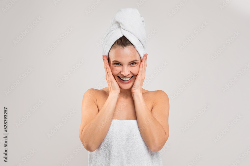 Bath Fun. Cheerful Middle Aged Woman Wrapped In Towel Over Light Background Bath Fun. Cheerful Middle Aged Woman Wrapped In Towel Over Light Background