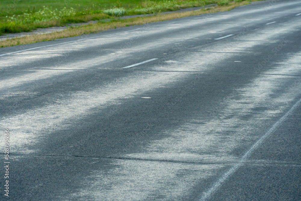 Empty asphalt road close-up against the sky. Empty background, space for text. New asphalt concrete pavement in rural areas. Empty asphalt road close-up against the sky. Empty background, space for text. New asphalt concrete pavement in rural areas.