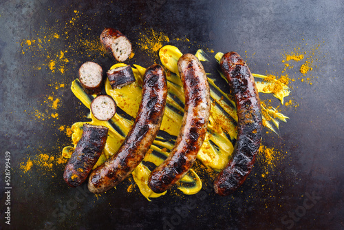 Fotografía Barbecue Allgäu bratwurst served with hot mustard and curry as top view on a rus