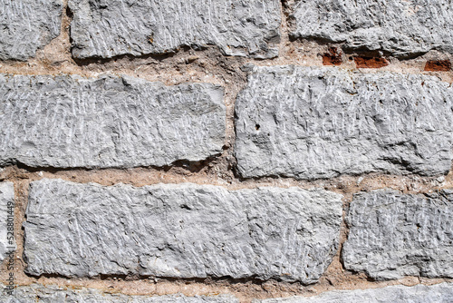 Old white stone wall made of gang-sawn limestone as a background