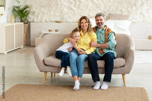 Cheerful Family Sitting On Couch In Modern Living Room Indoor