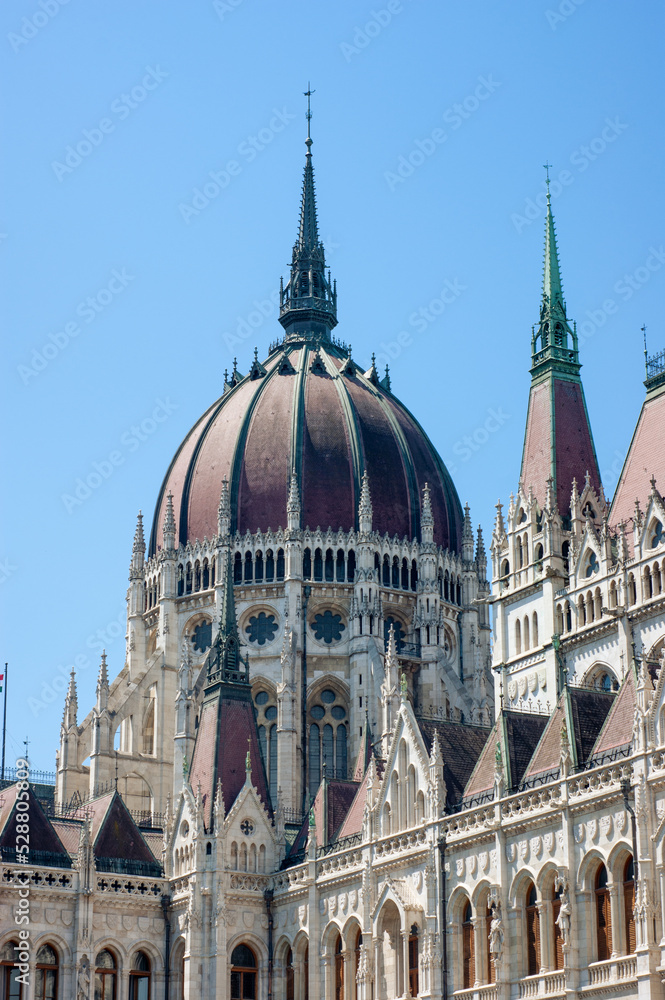 The red roof dome of the Parliament House in Budapest, Hungary, is only a small part of the massive government buildings with awesome spires, arches, towers, and railings.