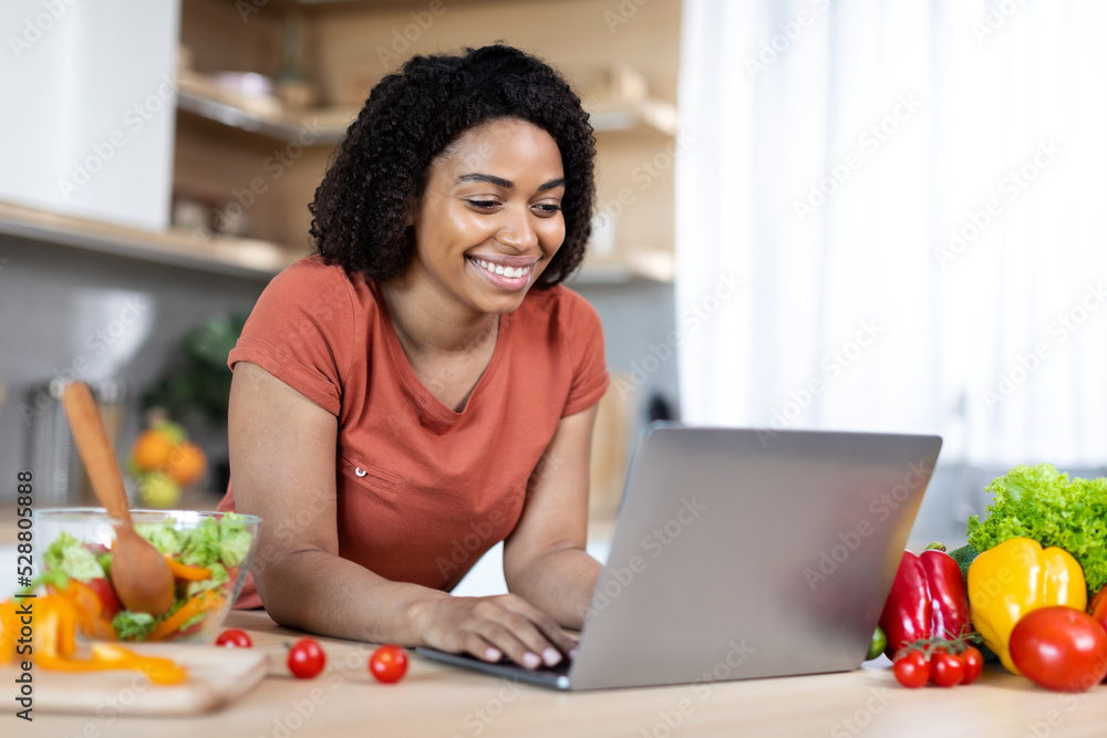 Glad young african american female blogger typing on laptop, have online chat