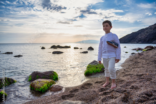 Boy walking on the beach in nice clothes. © Cabrera