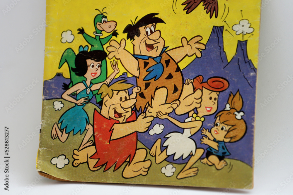 Old magazine of cartoons from the television series The Flintstones by  Hanna Barbera. Fred Flintstone, Barney Rubble, Vilma, Betty, Pebbles, Dino  and Bam Bam. Friendly families from the stone age. Stock Photo |