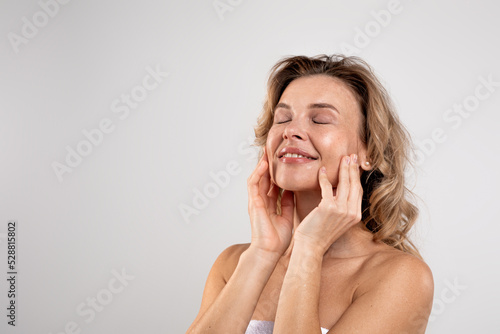 Spa Treatments. Attractive Middle Aged Woman With Beautiful Skin Touching Her Face