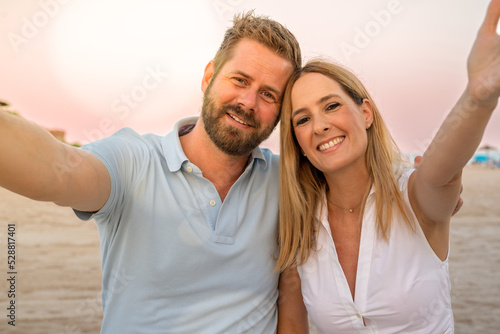 Loving cheerful happy couple taking selfie on the beach.