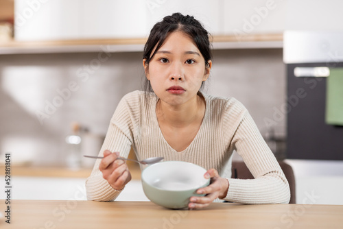 Fototapeta Unhappy chinese woman showing her empty plate