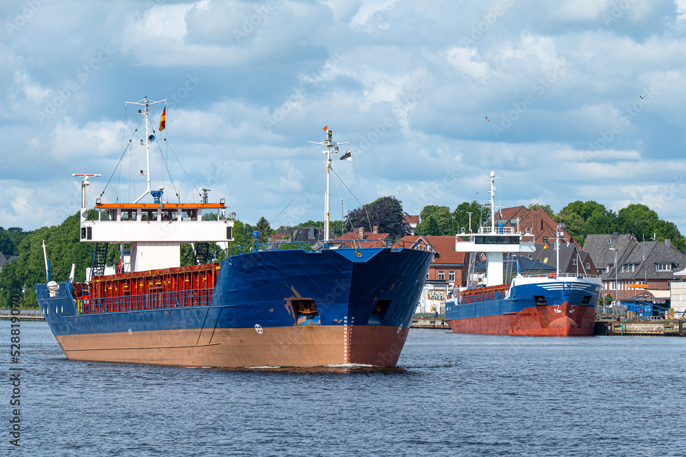 Fototapeta premium Schiffsverkehr auf dem Nord-Ostsee-Kanal bei Rendsburg mit Hafenanlagen