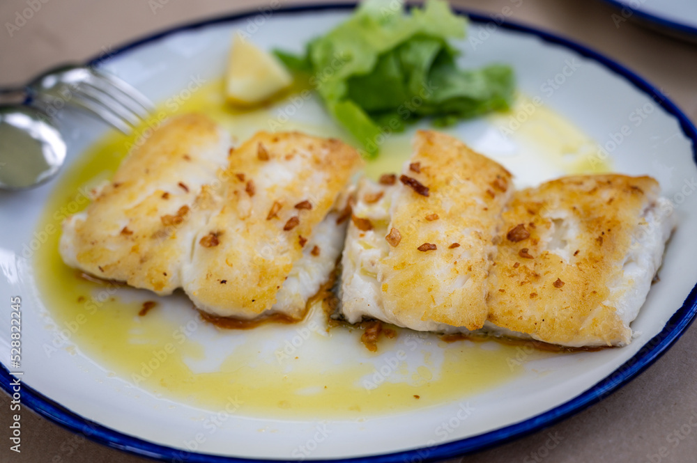 Grilled fillet of white codfish served in fish restaurant in San Sebastian, Basque Country, Spain Grilled fillet of white codfish served in fish restaurant in San Sebastian, Basque Country, Spain