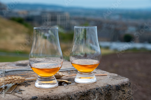 Tasting of single malt scotch whisky in glasses with view from Calton hill to new and old parts of Edinburgh city in rainy day, Scotland, UK © barmalini