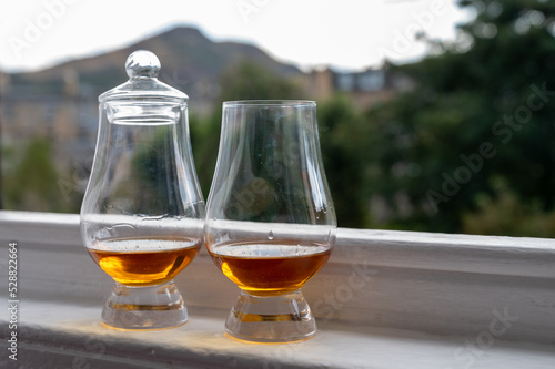 Two glasses of single malt scotch whisky served on old window sill in Scottisch house with view on old part of Edinburgh, Scotland, UK