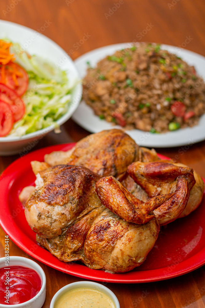 Fototapeta premium Grilled chicken with french fries on a wooden table. 