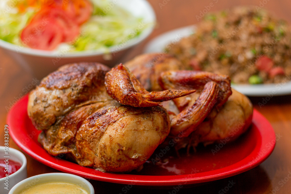 Grilled chicken with french fries on a wooden table.
