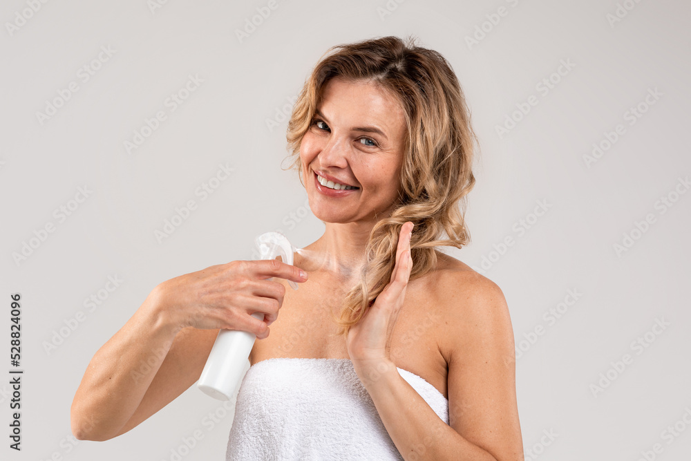 Haircare. Smiling Middle Aged Female Applying Moisturising Hair Spray On Dry Ends, Haircare. Smiling Middle Aged Female Applying Moisturising Hair Spray On Dry Ends,
