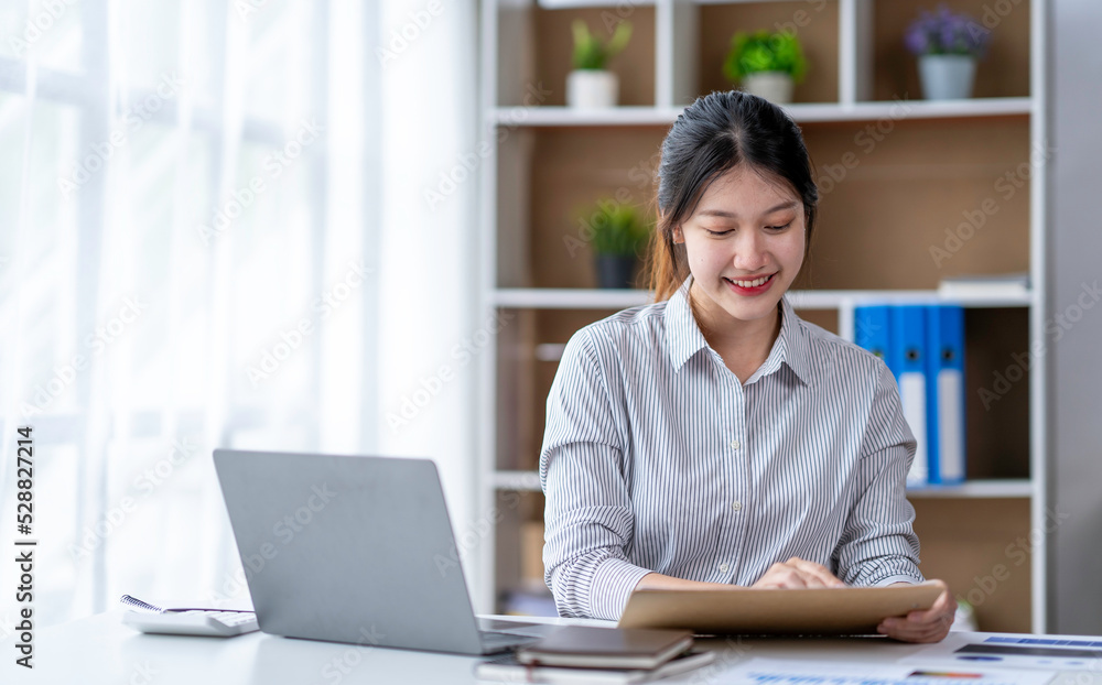 Young woman working on a laptop in the office. Asian businesswoman sitting at her workplace in the office. Beautiful Freelancer Woman working online at her home. Young woman working on a laptop in the office. Asian businesswoman sitting at her workplace in the office. Beautiful Freelancer Woman working online at her home.