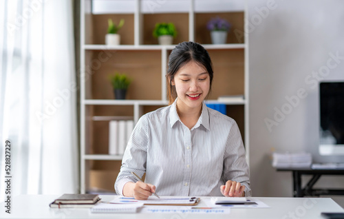 Asian business woman taking notes on online meetings on the Internet through a laptop in an open office business idea Data Analysis  Roadmap  Marketing  Accounting  Auditing