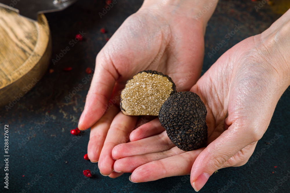 black truffle on women hands macro close up