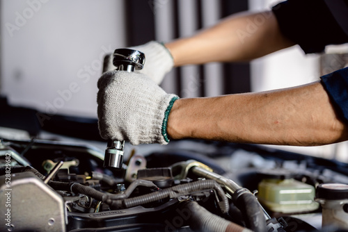 close up of view Auto mechanic repairman using a socket wrench working engine repair in the garage, change spare part, check the mileage of the car, checking and maintenance service concept.