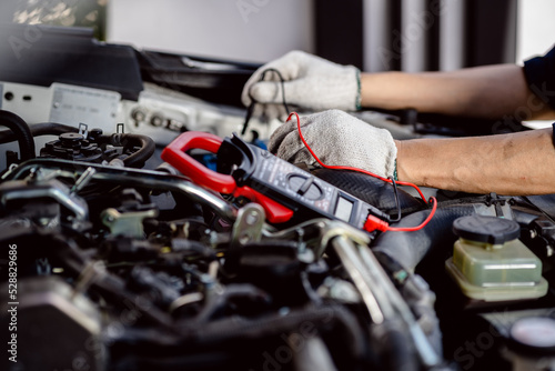 Wallpaper Mural Automotive mechanics repairman use digital voltage multimeter to check voltage level in car battery, check the mileage of the car, auto maintenance service concept. Torontodigital.ca