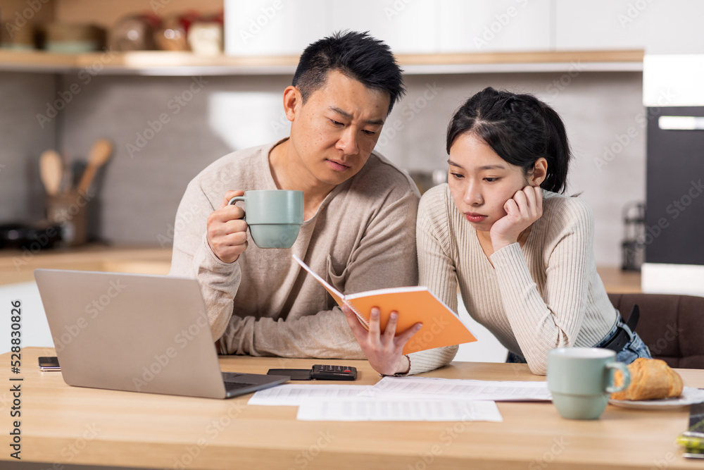Asian family planning monthly budget together, kitchen interior Asian family planning monthly budget together, kitchen interior