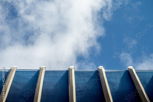 Blue and White Sky and Clouds Above a Blue and White Wall.