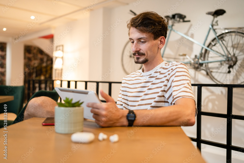 one caucasian man young adult millennial male using digital tablet one caucasian man young adult millennial male using digital tablet