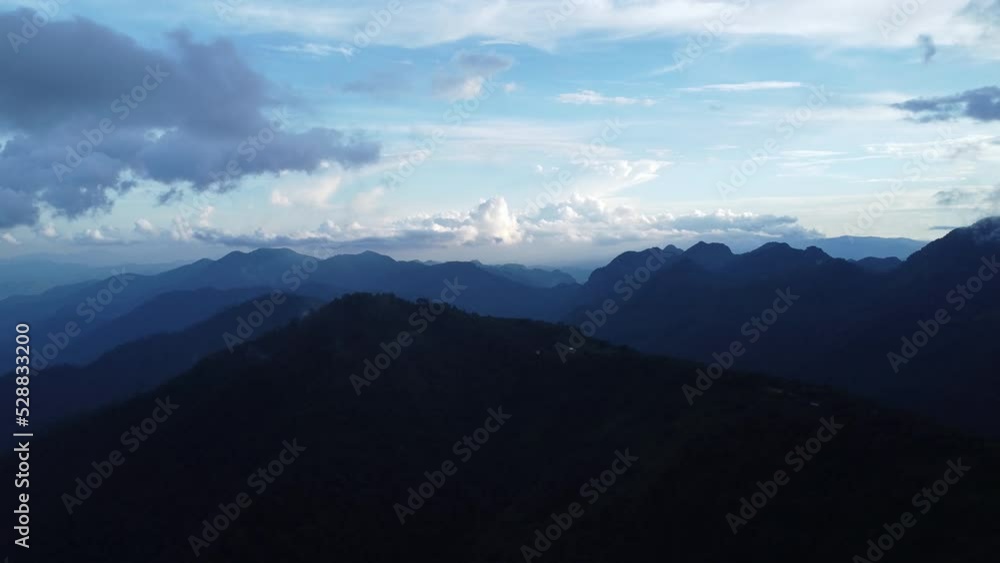 Aerial view of sea of fog on tropical mountains in the early morning. Layers of mountains in Thailand. Landscape of nature background in motion. Aerial view of sea of fog on tropical mountains in the early morning. Layers of mountains in Thailand. Landscape of nature background in motion.
