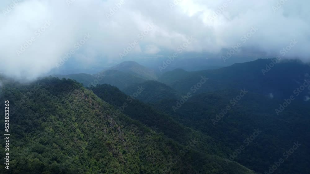 Aerial view of sea of fog on tropical mountains in the early morning. Layers of mountains in Thailand. Landscape of nature background in motion. Aerial view of sea of fog on tropical mountains in the early morning. Layers of mountains in Thailand. Landscape of nature background in motion.