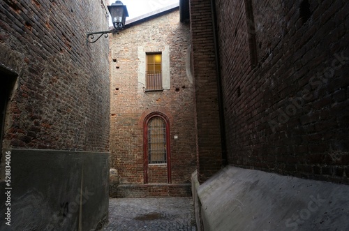 View of an alley around the Church of Santa Maria Assunta, early in the morning . Chivasso, Piedmont, Italy.