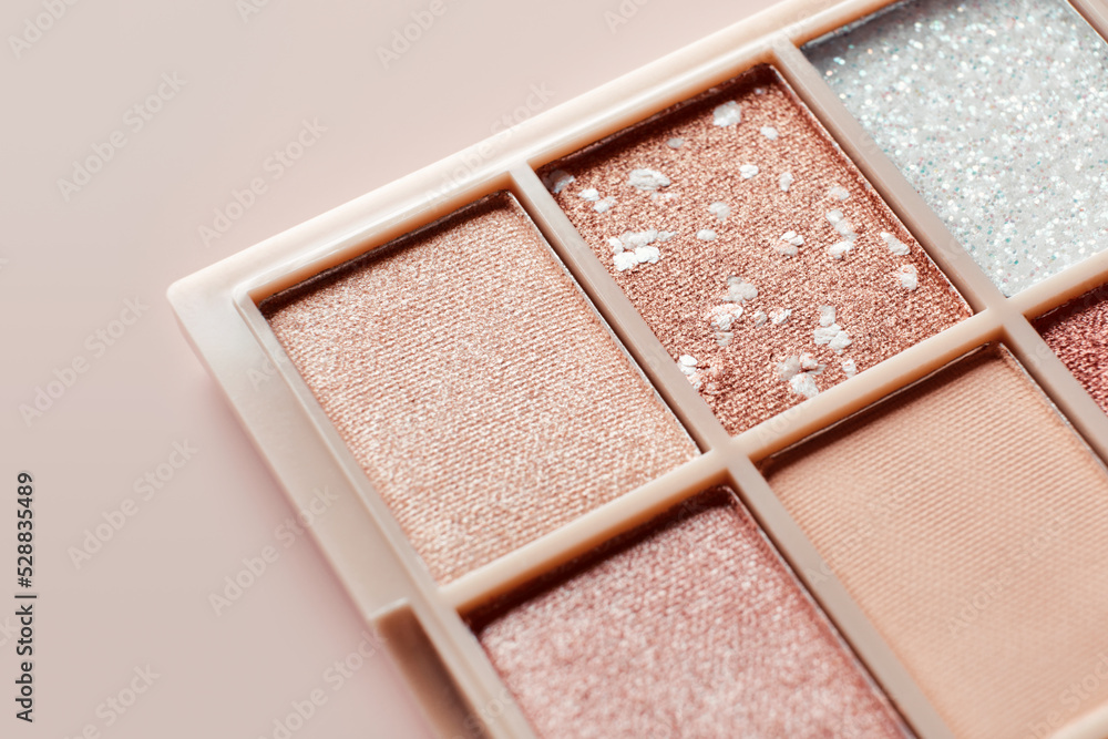 Fototapeta premium Eyeshadow colorful shades palette in beige tones close-up. Beauty abstract background