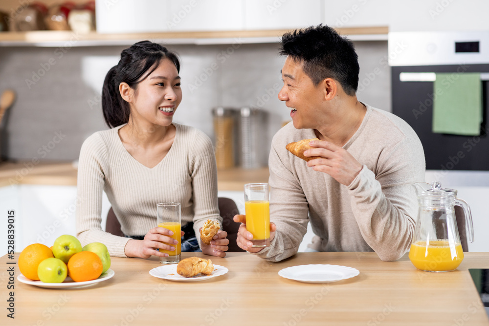 Cheerful korean lovers having snack together at home