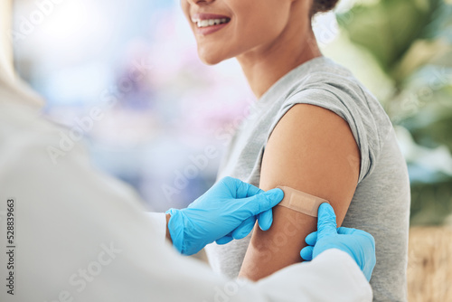 Band aid, vaccine or injection for covid and global virus in security, safety or wellness insurance. Doctor hands, medical employee or healthcare worker with plaster for happy or smile hospital woman