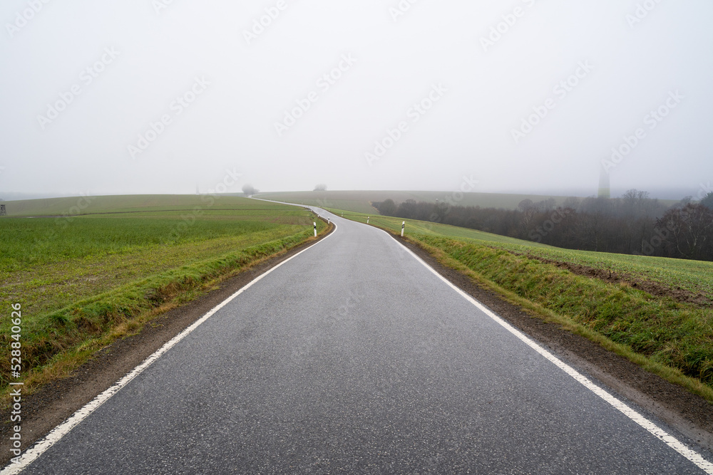 Long asphalt country road on a foggy autumn morning Long asphalt country road on a foggy autumn morning