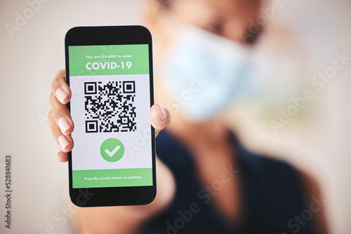 Covid passport, QR code and phone in the hand of a woman refugee or passenger ready for immigration and travel. Closeup of 5g mobile technology for safety during the global corona virus epidemic