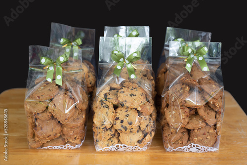 Homemade cookie in plastic bag with ribbon bow tie, food packaging concept.