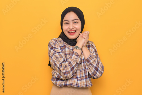Beautiful young Asian woman in plaid shirt smiling happy and looking confident isolated on yellow background © Sewupari Studio