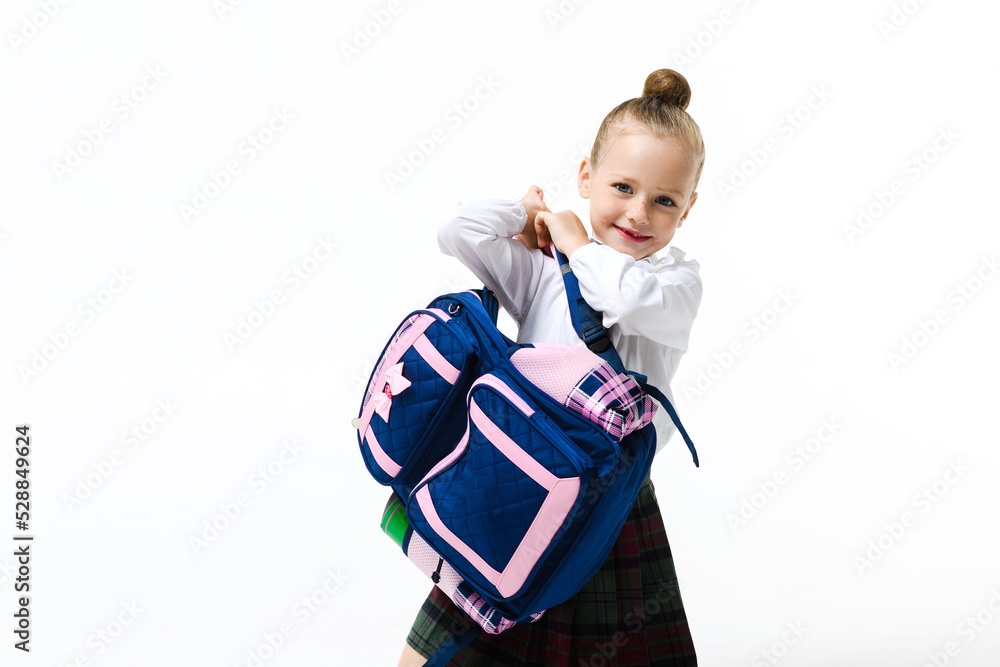 Cute girl in a school uniform lifts a huge school backpack Stock Photo