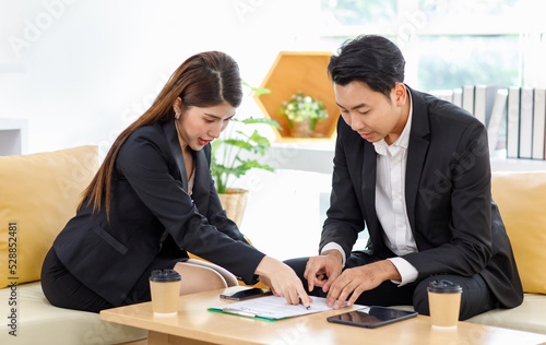 Wallpaper Mural Asian young beautiful professional successful businesswoman in formal suit sitting smiling holding tablet pointing showing information data from laptop notebook computer to male businessman colleague Torontodigital.ca