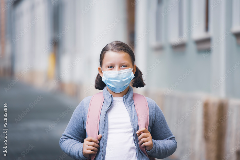 School girl with face mask in front of her school School girl with face mask in front of her school