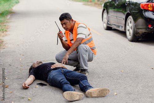 man accident lay down unconscious on the road hit by car during playing phone emergency team staff radio for help © Quality Stock Arts