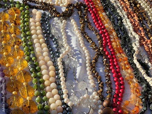 Сlose up of colorful beads. Beads made natural gems turquoise, malachite, mother of pearl, jade, quartz, agate, lapis lazuli, jasper, cacholong, tiger's eye stone, topaz, fluorite. photo
