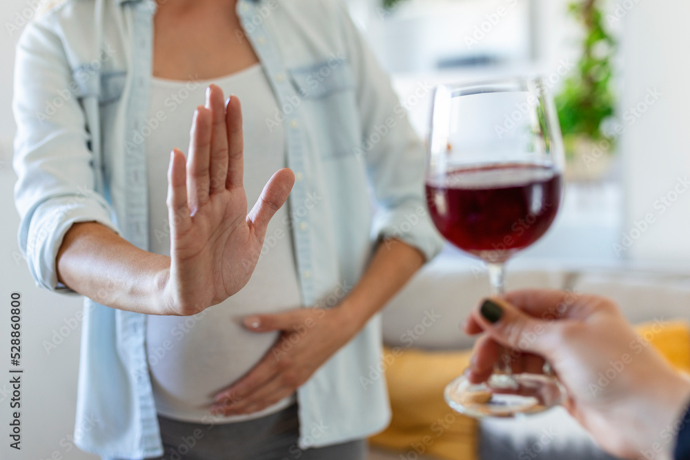 Pregnant woman refusing a glass of wine. Alcohol In Pregnancy. Unrecognizable Expectant Lady Gestring Stop To Offered Glass Of Wine Pregnant woman refusing a glass of wine. Alcohol In Pregnancy. Unrecognizable Expectant Lady Gestring Stop To Offered Glass Of Wine