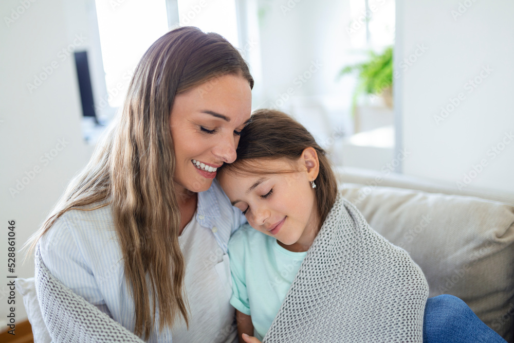 A nice girl and her mother enjoy sunny morning. Good time at home. Child wakes up from sleep. Family playing under blanket on the bed in the bedroom. A nice girl and her mother enjoy sunny morning. Good time at home. Child wakes up from sleep. Family playing under blanket on the bed in the bedroom.