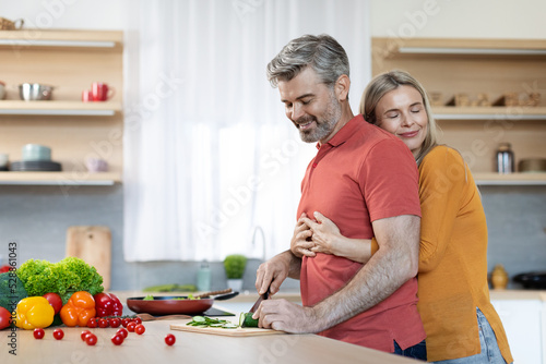 Loving handsome husband preparing delicious healthy meal for his wife