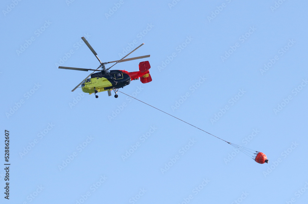 Helicopter with water to extinguish a fire Helicopter with water to extinguish a fire