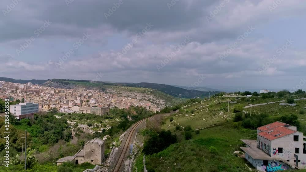 Tilt up shot over rail road with the view of Ragusa Ibla in Sicily, Italy in tbe background on a cloudy day. Tilt up shot over rail road with the view of Ragusa Ibla in Sicily, Italy in tbe background on a cloudy day.