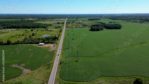 Hyperlapse Aerial Drone Top Fly Above Road with Power Lines Between Green Plain  photo